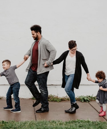 A man, a woman and two kids holdind hands